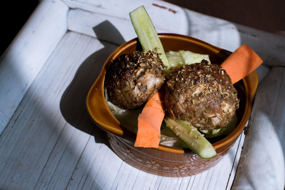 Savory homemade meatballs with fresh cucumber and carrot slices in a rustic bowl.